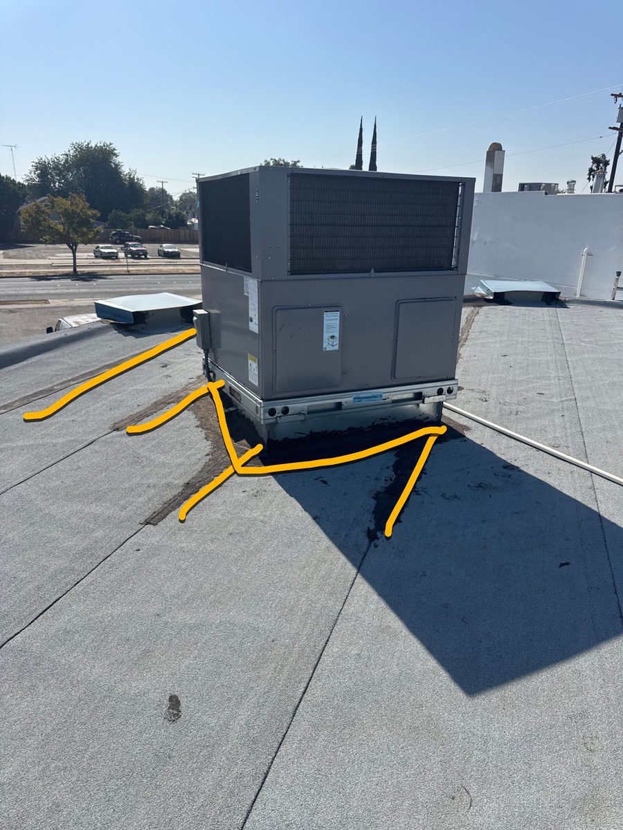 HVAC unit on commercial roof with yellow arrows drawn on photo pointing to seam failures around the base — Econo Roofing diagnostic estimate Beto's Bakery.