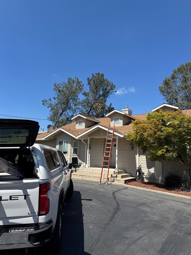 Front view of Jamestown home with ladder staged for roof replacement